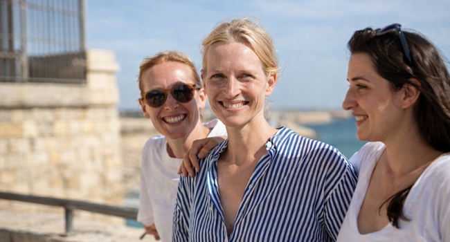 Bildungsurlaub am Meer für Erwachsene Drei Frauen stehen zusammen an einer Brüstung vor dem Meer bei einem Bildungsurlaub