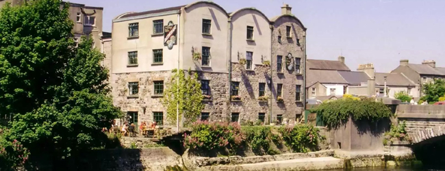 Gebäude der LISA! Sprachschule in Galway Historisches Gebaeude am Fluss in Galway mit Bäumen