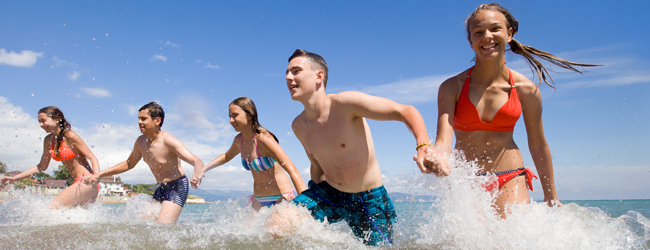 Jugendliche im Meer während einer Schülersprachreise Malta Gruppe von Jugendlichen läuft lachend durch das Meer während einer LISA! Schülersprachreise in Sliema