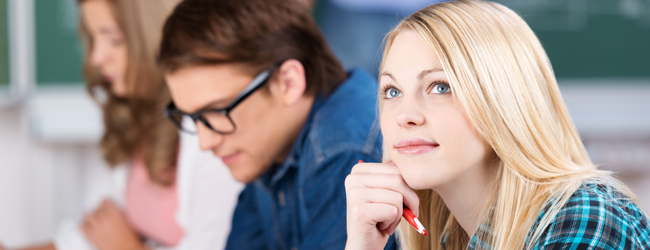 Blonde junge Erwachsene im Intensivsprachkurs Sprachreisen Englisch konzentriert im Klassenzimmer.