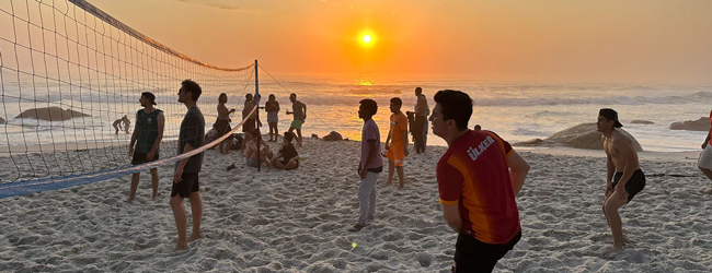 Viele Leute spielen bei Sonnenuntergang am Sandstrand auf einer LISA-Sprachreise in Suedafrika Kapstadt Beach-Volleyball