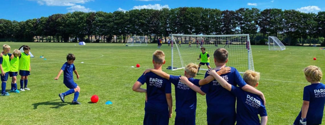 Englisch-Sprachreisen für Schüler in Fleetwood: Ein Junge schießt auf das Tor, umringt von weiteren Kindern im PSG-Trainingstrikot.