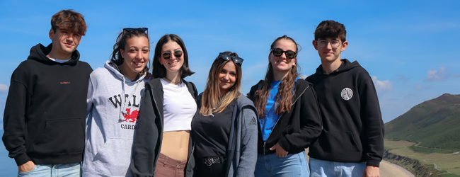 Sonniger Ausflug an die Küste von Wales bei einer LISA! Sprachreise Mehrere Jugendliche stehen als Gruppe vor der Kulisse der walisischen Küste